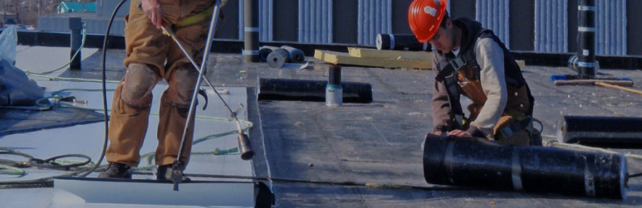 Unico roofers installing membrane on a flat roof